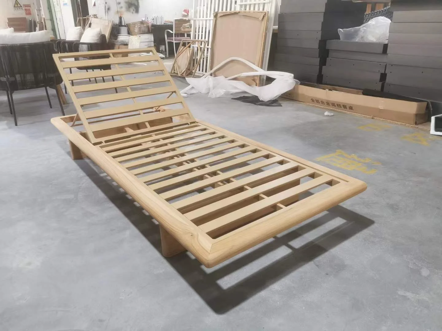 Front three-quarter view of a Adjustable-Platform-Teak-Chaise-Lounge without cushion and woven rope frame.